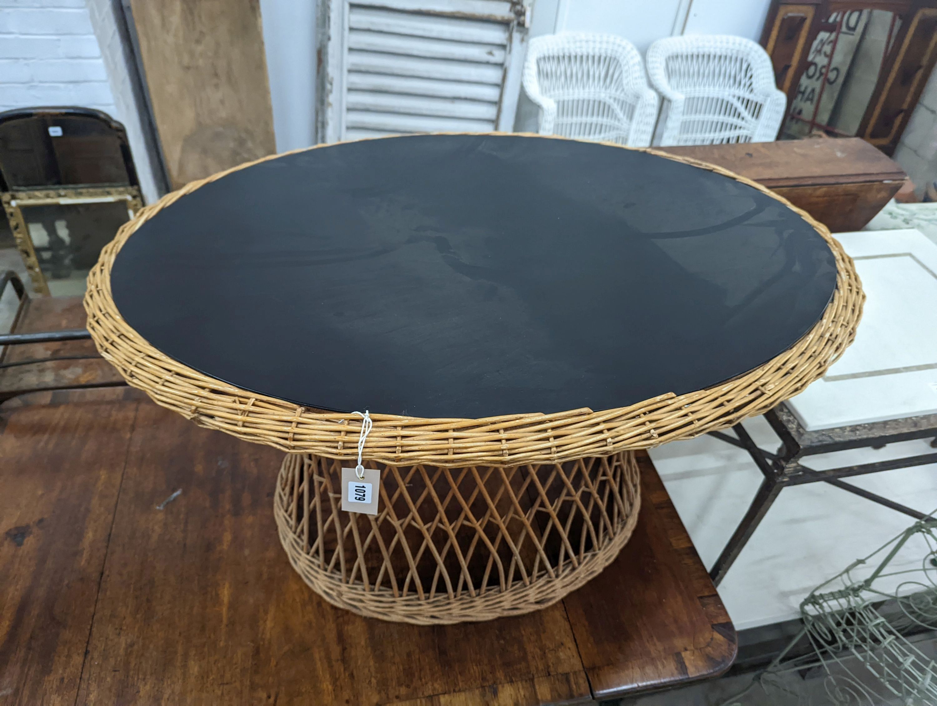 An oval rattan conservatory table, length 100cm, depth 71cm, height 60cm